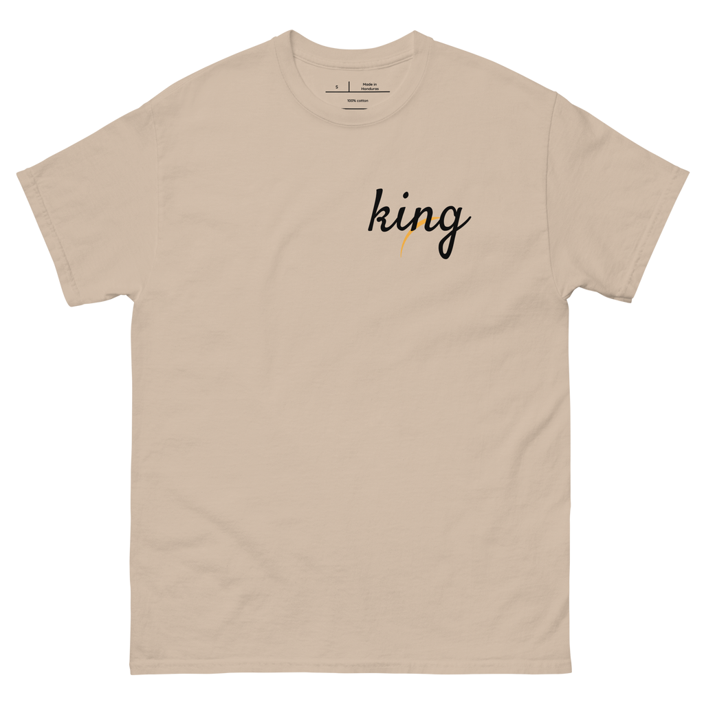 "Natural Tan t-shirt with white text that reads 'KING.' The shirt features a bold font and is perfect for making a statement. The design celebrates African heritage and identity, making it a great choice for anyone who is proud of their roots."