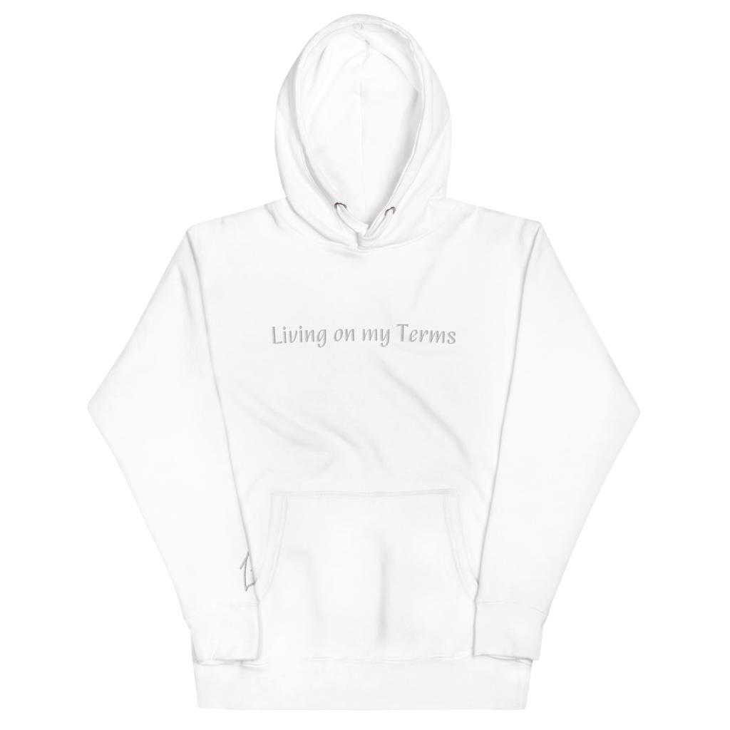 "White hoodie with White embroidered text that reads 'Living on my Terms'. The hoodie features a comfortable fit and a bold font. The design conveys a spiritual identity and sense of individuality, making it a great choice for anyone who is not afraid to stand up for what they believe in."